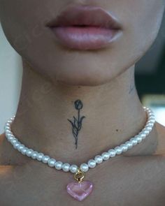 a close up of a woman's neck with a flower and heart on it