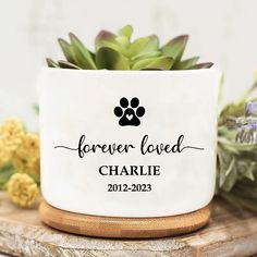 a white ceramic planter with a dog paw on it and the words, forever loved charlie 2012 - 202