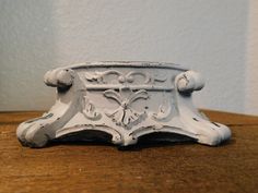 a small white clock sitting on top of a wooden table