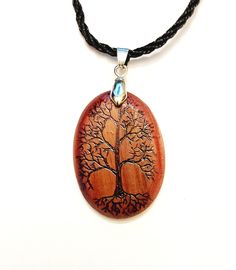 "This pendant is made from gorgeous red cedar wood. The Tree Of Life graphic is seared into the surface of the wood using a pyrography (wood burning) pen. The finish consists of multiple coats of glossy Spar Urethane. Designs for use on boats, this finish is far more resistant to UV and water than conventional polyurethane. Includes an 18\" nylon cord and all necessary hardware." Bohemian Natural Wood Necklaces As Gift, Bohemian Natural Wood Necklace As Gift, Handmade Mahogany Jewelry Gift, Bohemian Natural Wood Jewelry Gift, Bohemian Natural Wood Jewelry As Gift, Mahogany Handmade Jewelry For Gift, Handmade Mahogany Jewelry For Gift, Unique Mahogany Jewelry For Gift, Natural Wood Pendant Jewelry Gift