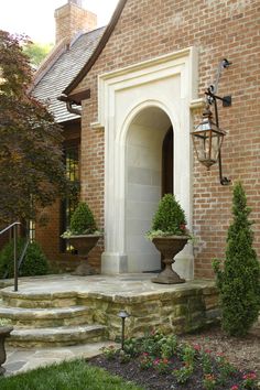 a brick house with stone steps leading up to the front door and entryway area