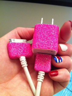 a hand holding a pink and white cell phone charger