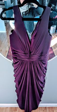 a purple dress hanging up in front of a mirror