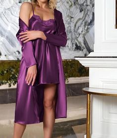 This elegant purple satin chemise and robe set is designed to captivate with its sophisticated details. The set features: Fabric: Soft and lightweight satin Color: Purple Cut: Mini length Lace Accents: Delicate lace details on the top Set Includes: Chemise and robe The chemise and robe are thoughtfully coordinated to offer a graceful look, making it a perfect choice for special occasions or a comfortable night in. Why You Should Buy It: Sophisticated Elegance: The rich purple satin and lace acce Purple Satin Dress For Night Out, Purple Satin Sleepwear, Long Sleeve Satin Nightgown For Party, Robe Pajamas, Satin Chemise, Adult Pajamas, Women's Nightgowns, Purple Satin, Satin Color