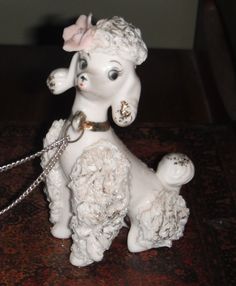 a white ceramic figurine with a pink bow on it's head sitting on a table