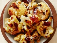 a white bowl filled with roasted cauliflower on top of a table