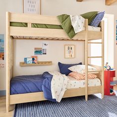 there is a bunk bed with blue sheets and pillows on the bottom level, next to a red table