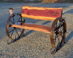 a wooden bench sitting on top of a gravel road