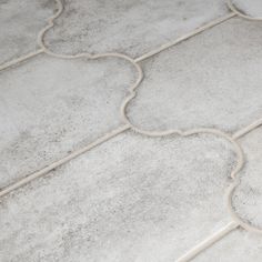 a close up view of a white tile floor with an intricate design on the border