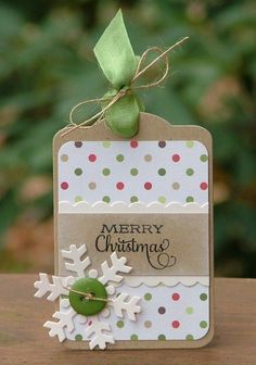 a christmas card with a snowflake on it and a green bow hanging from the top