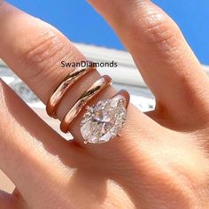 a woman's hand with two rings on it and a diamond in the middle