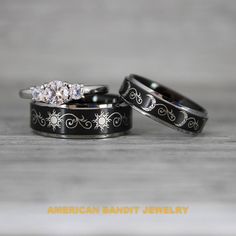 two black wedding bands with white diamonds on them