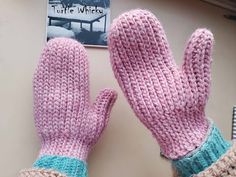 two pink mittens sitting on top of a table