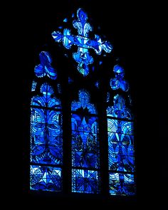 a large stained glass window in a dark room