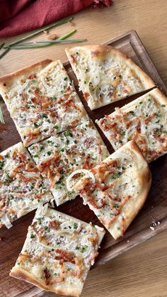 sliced pizza sitting on top of a wooden cutting board