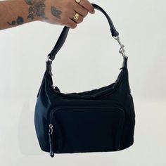 Pre-Owned Coach Black Canvas Mini Shoulder Bag With A Leather Strap, Zip Pocket At Front And Slip Pocket At Back, Top Zip Closure And Silver Tone Hardware. Interior Includes One Zip Pocket And Two Slip Pockets. Very Good Condition, No Major Signs Of Wear. Size: 9" Length X 4.5" Depth X 8" Height With 8" Strap Drop Versatile Tote Bag With Silver-tone Hardware, Travel Shoulder Bag With Silver-tone Hardware, Classic Hobo Bag With Silver-tone Hardware For Everyday Use, Everyday Shoulder Bag With Silver-tone Hardware, Versatile Shoulder Bag With Silver-tone Hardware For Everyday Use, Versatile Travel Bag With Palladium Hardware, Modern Baguette Bag With Silver-tone Hardware For Shopping, Everyday Hobo Shoulder Bag With Silver-tone Hardware, Everyday Satchel Baguette Bag With Silver-tone Hardware