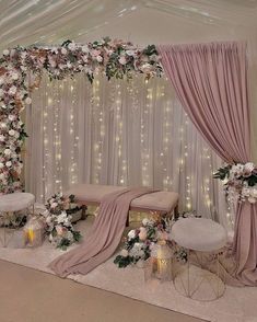 a wedding ceremony setup with flowers and candles on the side wall, draped drapes