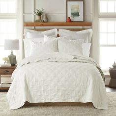 a bed with white linens and pillows in a bedroom