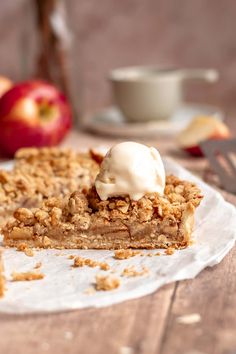 a piece of pie sitting on top of a white paper plate next to an apple