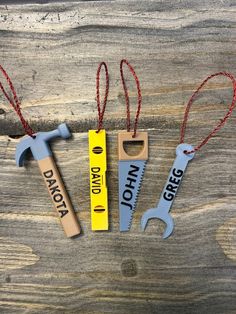 three different types of tools are hanging on a wooden table with red string and tags