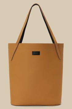 a tan leather tote bag with black handles