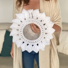 a woman is holding a crocheted doily