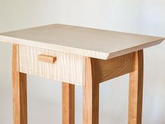 a small wooden table with one drawer on it