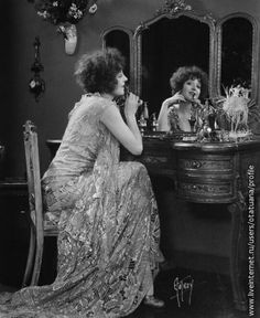 two women sitting at a table in front of a mirror