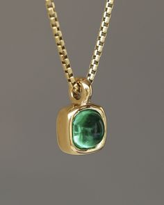 A juicy green emerald rounded square gem inside a solid 18k yellow gold bezel, hanging on a solid 14k yellow gold box chain. Sovereign Pendant by George Rings. Classic Green Emerald Necklace With Bezel Setting, Elegant Green Jewelry With Box Chain, Gold Cabochon Jewelry For May Birthstone, Gold Tsavorite Emerald Necklace For May Birthstone, Green Square Pendant Jewelry For Formal Occasions, Green Polished Finish Necklace For May Birthstone, Polished Emerald Jewelry For May Birthstone, Green Polished Necklace For May Birthstone, Green Polished May Birthstone Necklaces