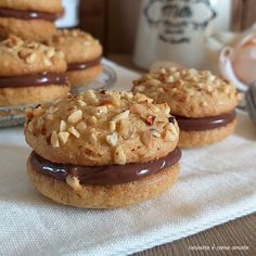 three cookies with chocolate frosting and nuts on top