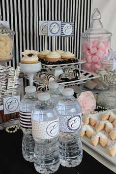 an assortment of desserts and sweets displayed on a table with black and white stripes