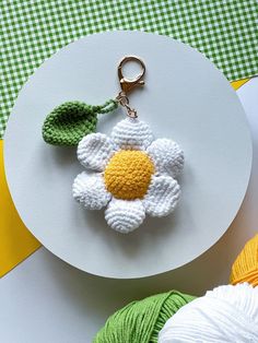 a crocheted keychain with a flower on it sitting on top of a white plate