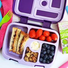 a purple lunch box filled with fruit and veggies