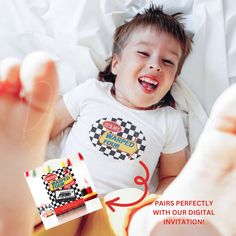 a young child laying on top of a bed next to a box of chips and an apple