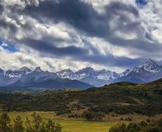 the mountains are covered in snow and clouds