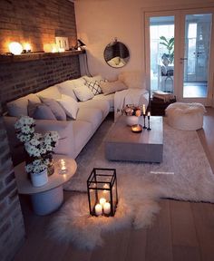 a living room filled with lots of furniture and candles on top of the coffee table