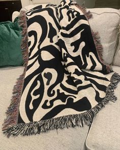 a black and white blanket sitting on top of a couch