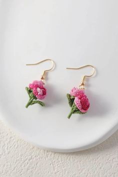 pink carnation earrings on a white plate