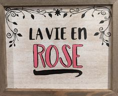 a sign that says la vie en rose in black and pink on a white background