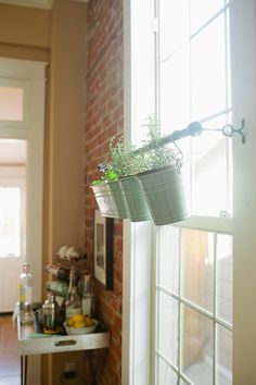 a window sill with two plants hanging from it