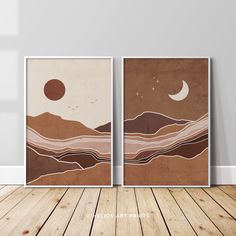 two posters with mountains and the moon on them are shown in an empty room next to a wooden floor