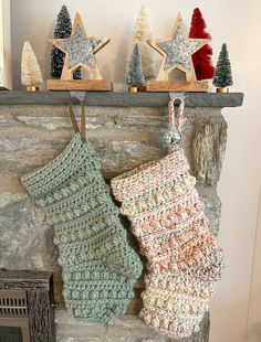 two stockings hanging on a fireplace with christmas decorations