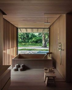 the inside of a bathroom with wooden walls and flooring, along with a large window