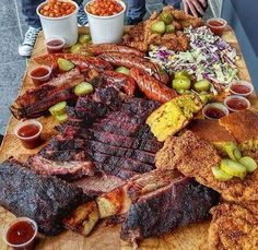 a wooden table topped with lots of different types of meats and other food items