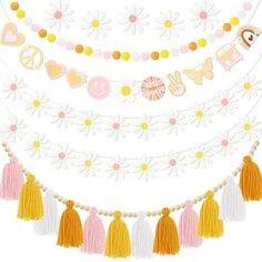 an assortment of tassels and decorations hanging from a string on a white background