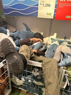 a man laying on top of a pile of stuffed animals next to other stuffed animals