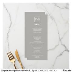 a table setting with silverware, fork and menu card on marble counter top next to gold utensils