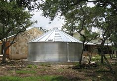 a large metal tank sitting in the middle of a forest