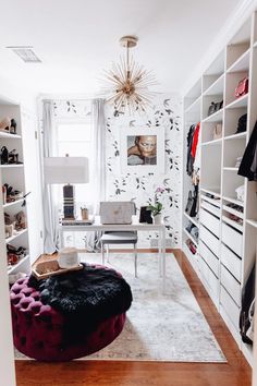 a room with a desk, chair and shelves filled with clothes on it's walls