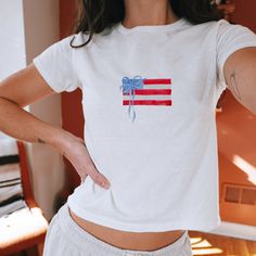 "Preppy American Flag Paint" 4th Of July Fourth Of July Americana Coquette Graphic Slogan Printed On Aesthetic Retro Vintage 90s Y2k Baby Tee Shirt with our own unique font.  🎨 Available in White, Light Pink, Light Blue, Navy, Black. If you need a different color, please let us know! (Ash, Red, Sport Grey & Green)  🎁 Our baby tees are perfect gift for her or him offering timeless fashion and versatility that anyone will cherish. Baby tees, popular in the '90s, have short sleeves and a slightly Coquette Graphic, Americana Coquette, Baby Tees 90s, American Flag Painting, Baby Tee Shirt, Life Pics, Fun List, Unique Font, Baby Tee Shirts